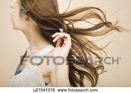 Stock Photograph - Young woman with hand in hair. Fotosearch