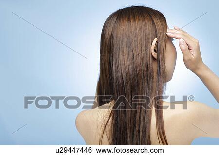 Young woman with hand in hair View Large Photo Image Stock Photograph - Young woman with hand in hair. Fotosearch