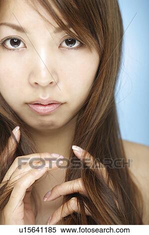 Stock Photography - Young woman with hand in hair. Fotosearch
