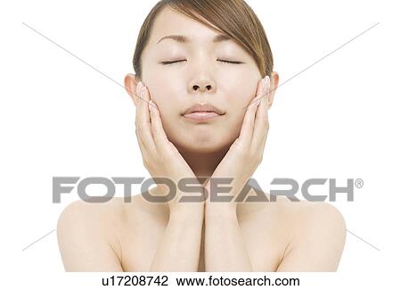 Stock Image - Young woman with hand on chin. Fotosearch