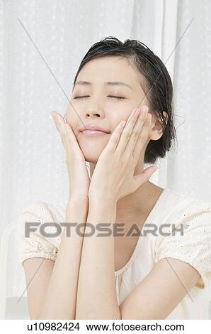Picture - Young Woman with Hands on Her Face. Fotosearch
