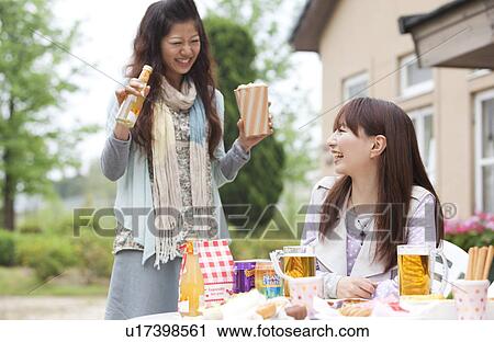 Young women eating at an outdoor cafe View Large Photo Image Stock Image - Young women eating at an outdoor cafe. Fotosearch