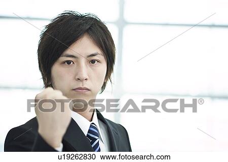 Stock Image - A businessman holding up fists. Fotosearch