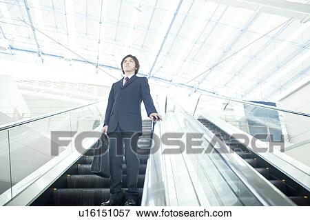 A businessman taking the escalator View Large Photo Image Stock Photo - A businessman taking the escalator. Fotosearch
