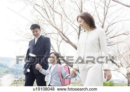 Stock Photo - A family under cherry blossom trees. Fotosearch
