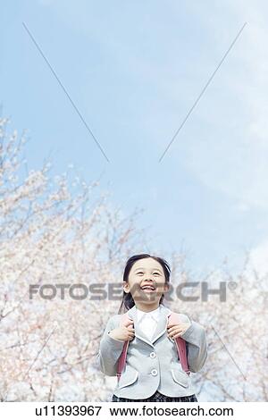 Stock Photo - A girl carrying a school bag. Fotosearch