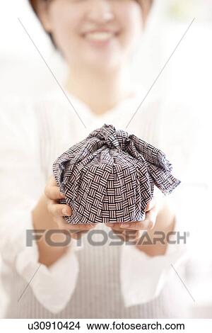 Picture - A woman holding a lunch box wrapped. Fotosearch