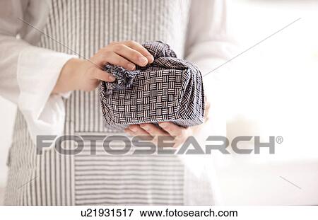 A woman holding a lunch box wrapped View Large Photo Image Stock Photo - A woman holding a lunch box wrapped. Fotosearch