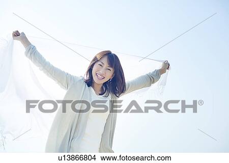 Picture - A young woman holding a white cloth. Fotosearch