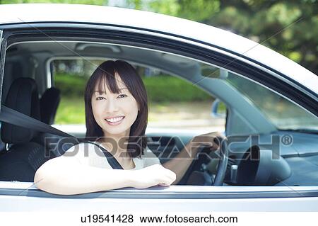 Stock Photo - A young woman in a car. Fotosearch