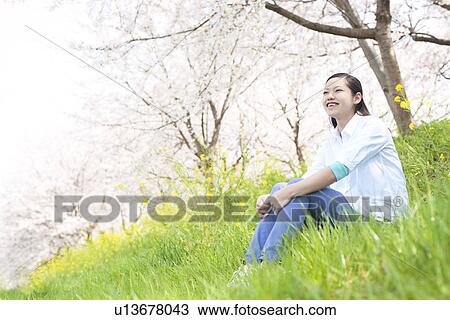 A young woman sitting on the bank View Large Photo Image Stock Image - A young woman sitting on the bank. Fotosearch