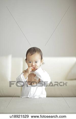 Baby eating orange View Large Photo Image Stock Photo - Baby eating orange. Fotosearch