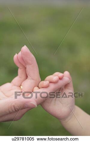 Stock Photography - Baby holding Mother's finger. Fotosearch