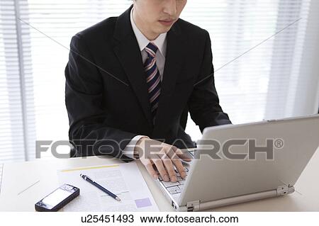 Stock Image - Businessman using laptop. Fotosearch