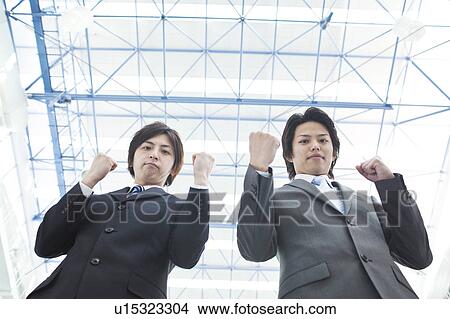 Picture - Businessmen making fists, low angle view. Fotosearch
