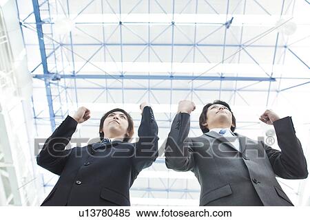 Stock Photography - Businessmen making fists, low angle view. Fotosearch