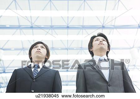 Businessmen standing, low angle view View Large Photo Image Stock Photography - Businessmen standing, low angle view. Fotosearch