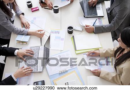 Businesspeople having a meeting, high angle view View Large Photo Image Stock Image - Businesspeople having a meeting, high angle view. Fotosearch