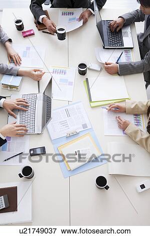 Businesspeople having a meeting, high angle view View Large Photo Image Stock Photo - Businesspeople having a meeting, high angle view. Fotosearch