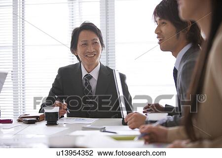 Stock Image - Businesspeople having a meeting. Fotosearch