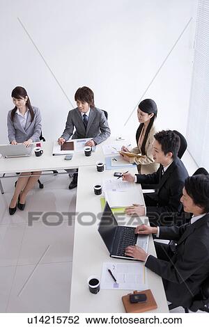 Stock Image - Businesspeople having a meeting. Fotosearch