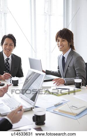 Stock Image - Businesspeople having a meeting. Fotosearch