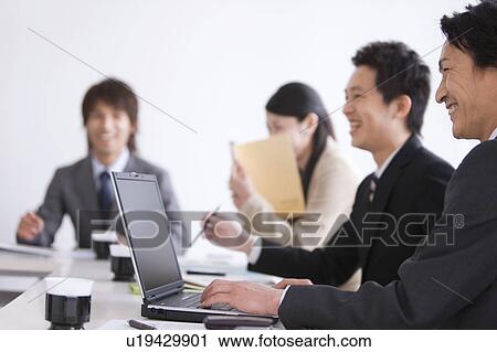 Stock Image - Businesspeople having a meeting. Fotosearch
