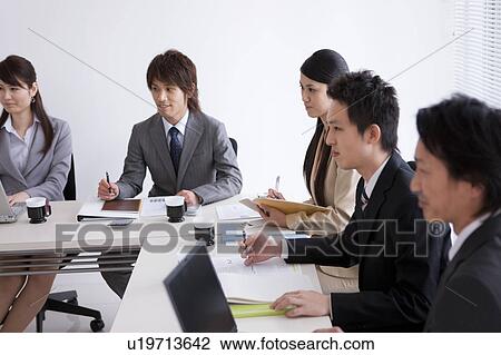Stock Image - Businesspeople having a meeting. Fotosearch