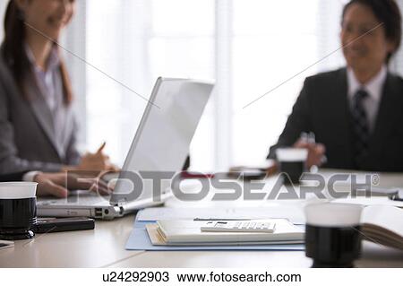 Stock Image - Businesspeople having a meeting. Fotosearch