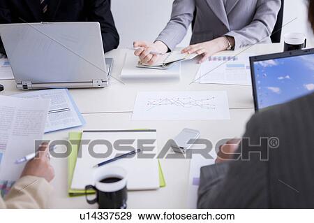 Stock Photo - Businesspeople having a meeting. Fotosearch