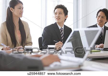 Stock Photo - Businesspeople having a meeting. Fotosearch