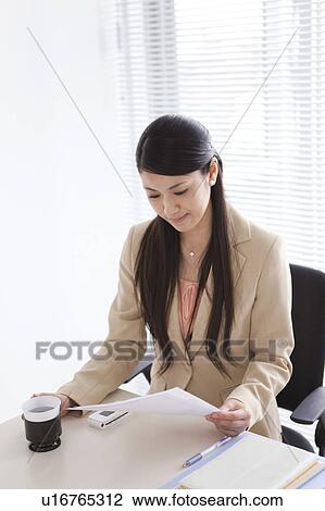 Businesswoman sitting at her desk View Large Photo Image Stock Image - Businesswoman sitting at her desk. Fotosearch