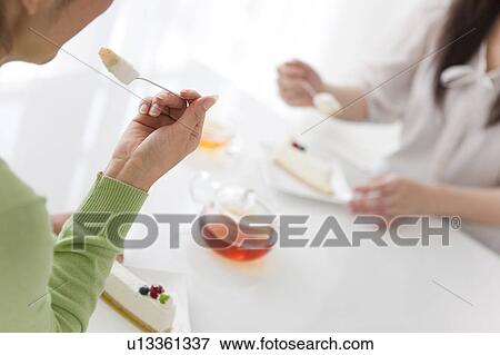 Stock Photo - Close Up of Two Women Eating Cake. Fotosearch