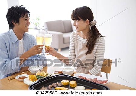 Stock Image - Couple Toasting at Dinner Table. Fotosearch