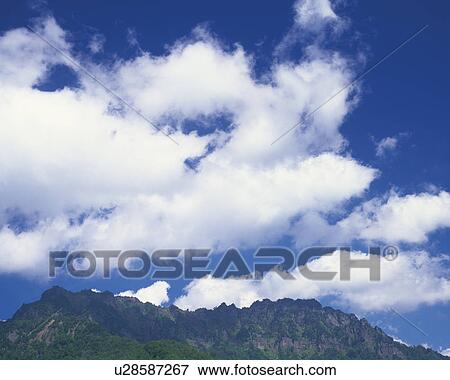 Stock Photo - Cumulus Clouds Over Mountains. Fotosearch
