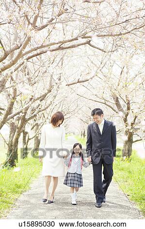 Stock Image - Family holding hands and walking. Fotosearch