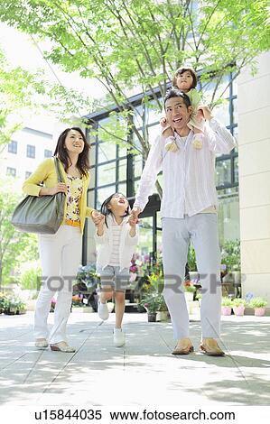 Stock Photography - Family of Four, Father Carrying Daughter on Shoulders. Fotosearch
