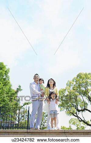 Stock Image - Family of Four on Steps Looking Up. Fotosearch