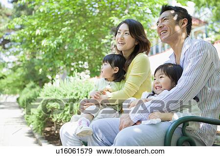 Family of Four Sitting on Bench View Large Photo Image Stock Photo - Family of Four Sitting on Bench. Fotosearch