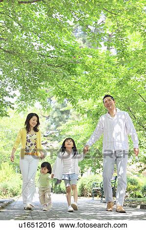 Stock Photograph - Family of Four Walking in Park. Fotosearch