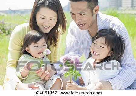 Stock Image - Family of Four with Bunch of Wildflowers. Fotosearch