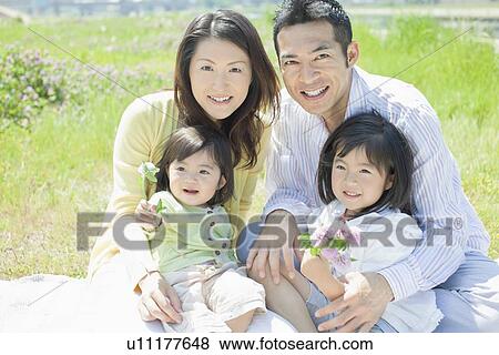 Stock Photo - Family of Four with Bunch of Wildflowers. Fotosearch