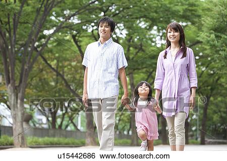 Stock Photograph - Family of Three Walking Hand in Hand. Fotosearch