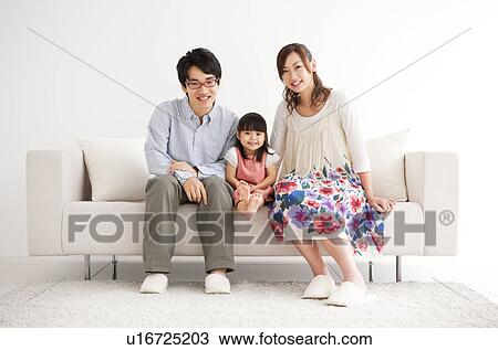 Stock Image - Family sitting on sofa . Fotosearch