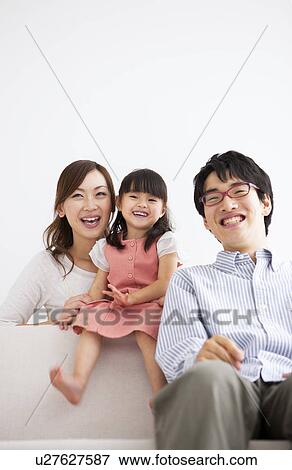 Family sitting on sofa View Large Photo Image Stock Photo - Family sitting on sofa . Fotosearch