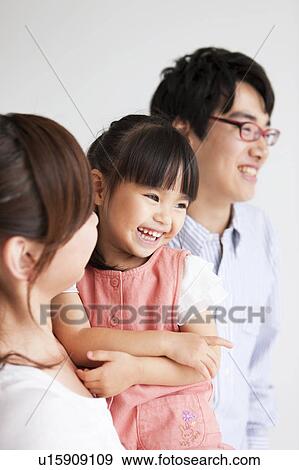 Stock Photo - Family standing and smiling. Fotosearch