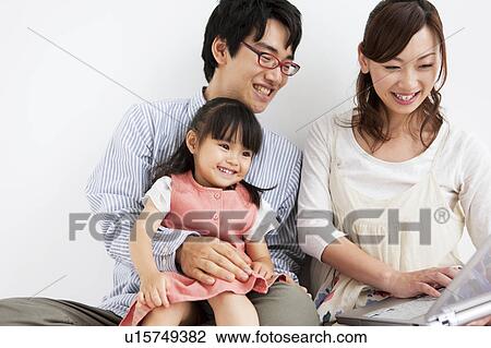 Stock Image - Family using laptop. Fotosearch