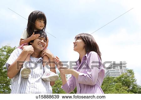 Father Carrying Daughter on Shoulders, Mother Beside View Large Photo Image Stock Photo - Father Carrying Daughter on Shoulders, Mother Beside. Fotosearch