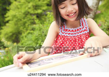 Picture - Girl Drawing on Blackboard. Fotosearch