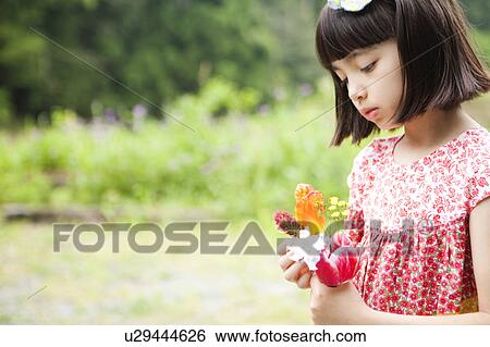 Stock Photograph - Girl Holding Bunch of Flowers. Fotosearch